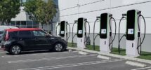 Sähköauto pysäköitynä neljän pikalatausaseman viereen